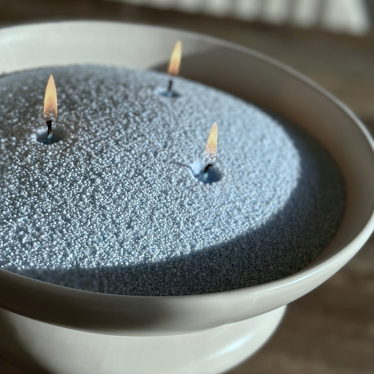 blauw kaarsenzand met 3 katoenen lonten in witte pot